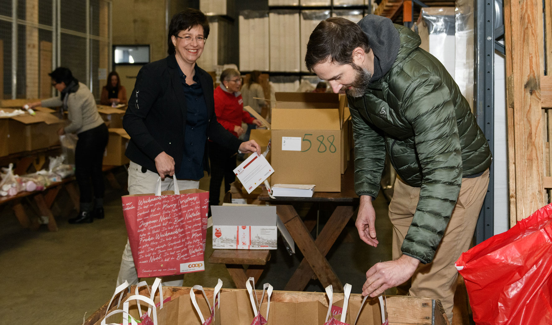 Margrit Koch, CEO der OKB und OKB-Mitarbeiter Sandro Widmer sind engagiert bei der Sache für 2 x Weihnachten